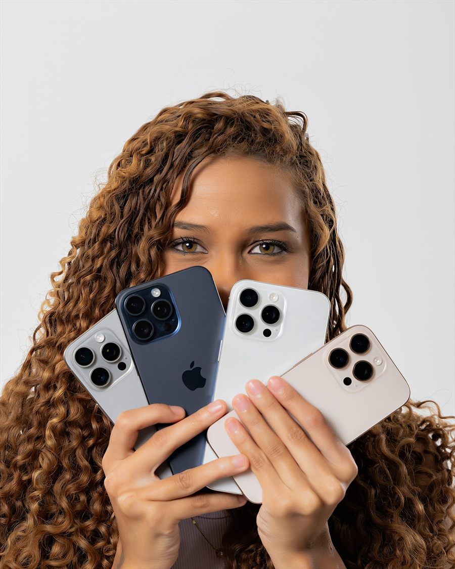 Influenciadora segurando quatro iPhones em leque diante do rosto